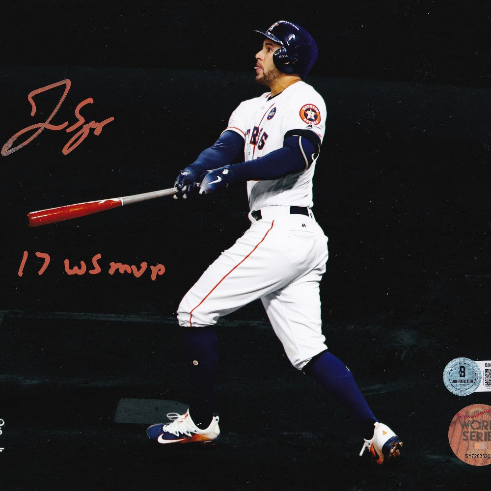 An autographed 8x10 photograph of baseball player George Springer in a Houston Astros uniform, captured mid-swing on a dark background with red handwritten signatures and World Series stamps.